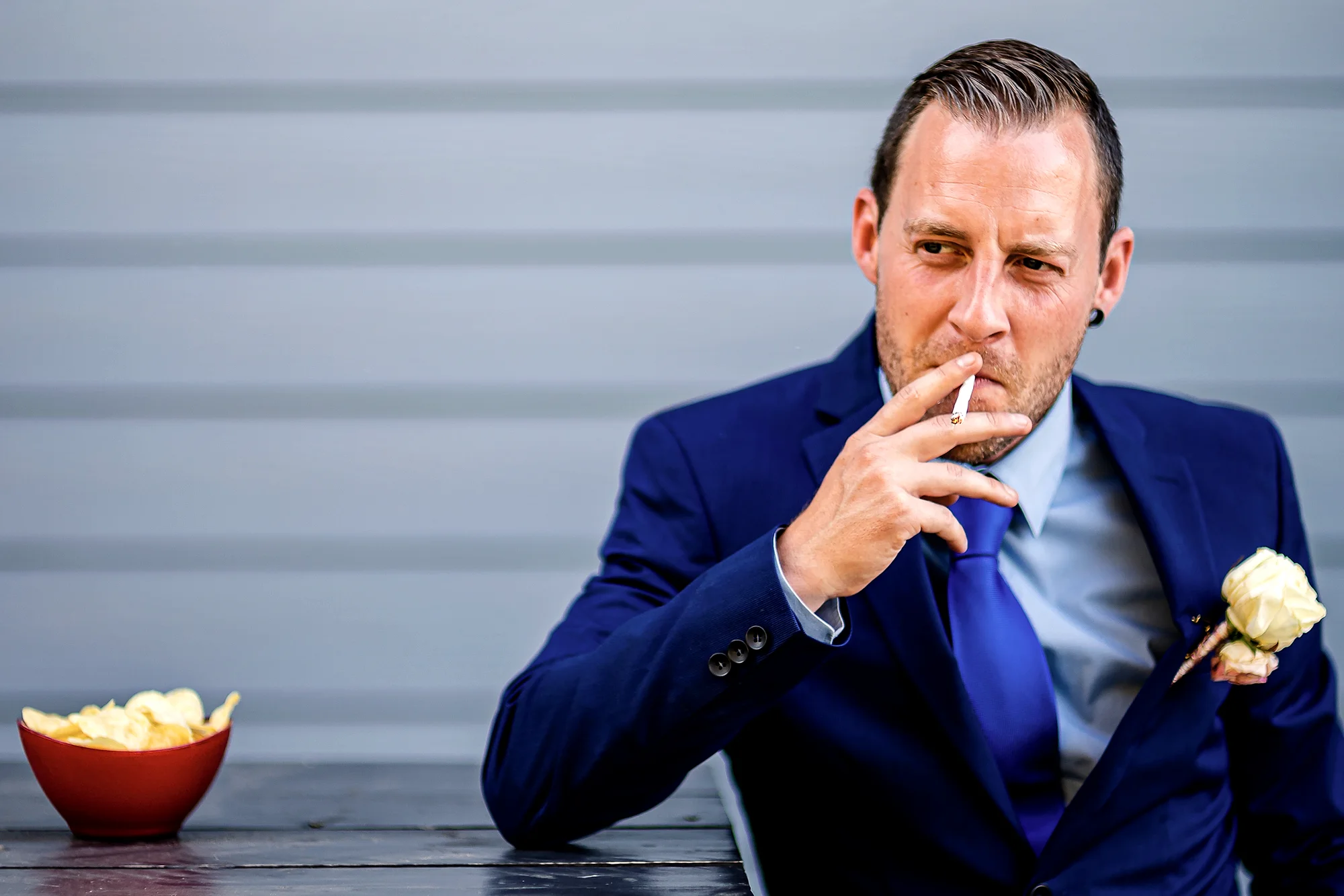 Bruidegom met sigaret en kommetje chips