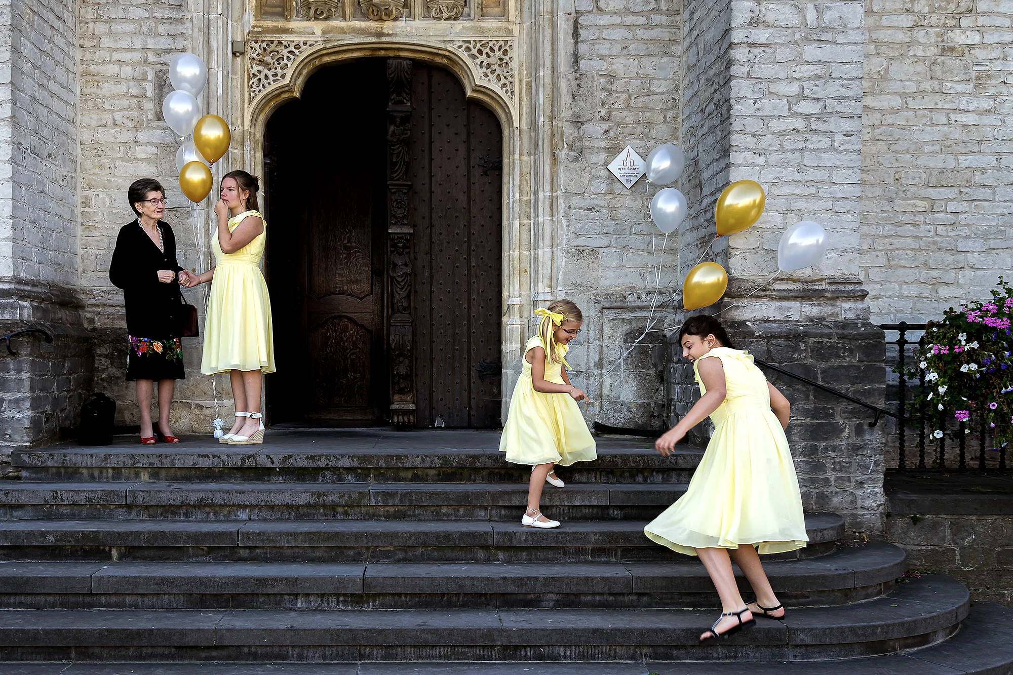 Bruidsmeisjes in geel met ballonnen op kerkstoep